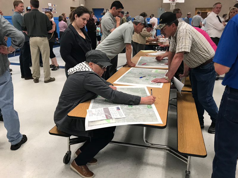 People surveying and marking up maps at the Community Kick-Off Meeting.
